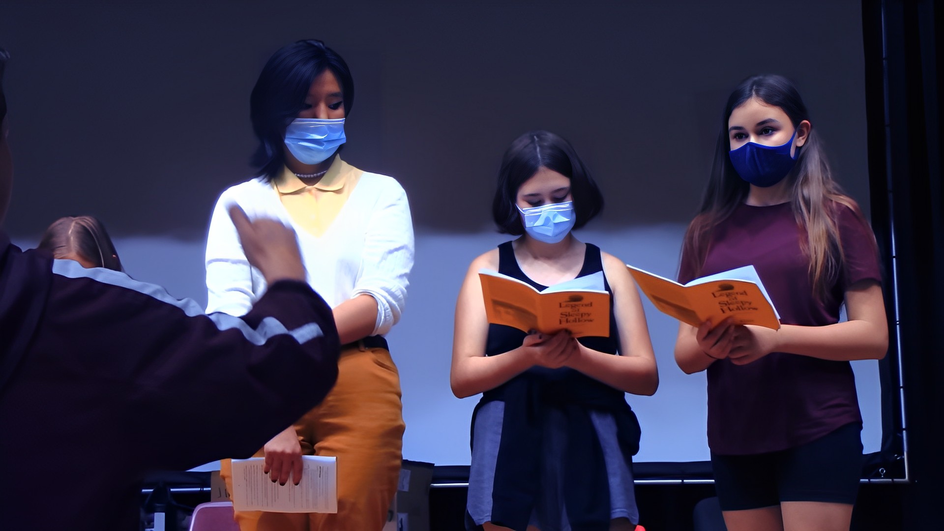 group of girls on stage with scripts